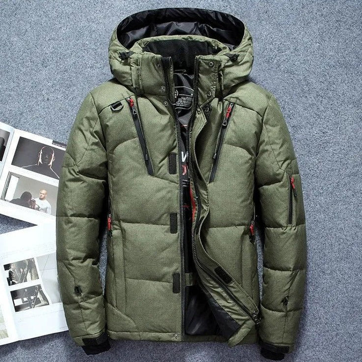 Green winter jacket with a hood on a gray surface